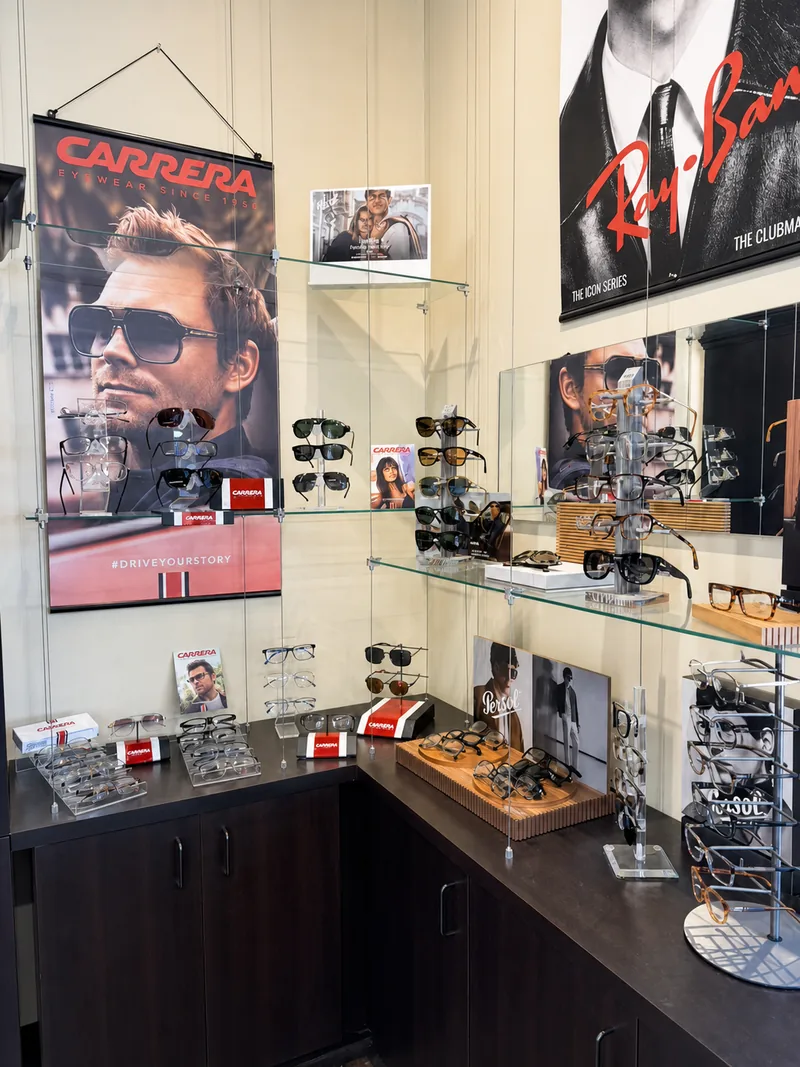 Carrera and Ray-Ban sunglasses displayed beneath framed brand artwork in the boutique