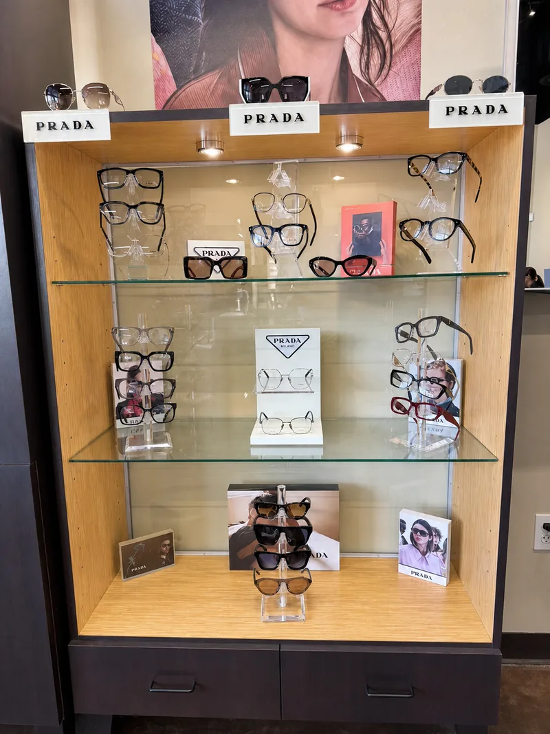 Prada eyewear displayed in a lit wood-and-glass case at the boutique
