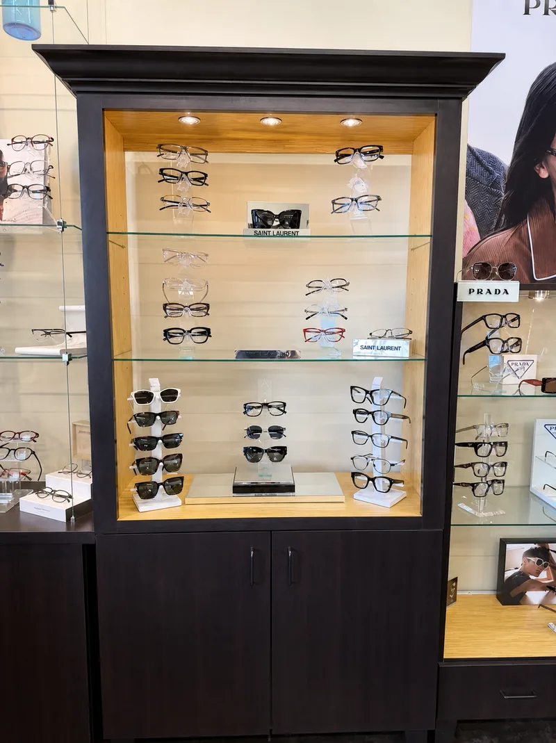 Saint Laurent and Prada eyewear in an illuminated display cabinet at the boutique